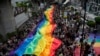 泰国即将实现同性婚姻合法化，在六月的“骄傲月”第一天，巨幅彩虹旗飘扬曼谷街头。（美联社）