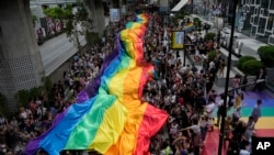 泰国即将实现同性婚姻合法化，在六月的“骄傲月”第一天，巨幅彩虹旗飘扬曼谷街头。（美联社）