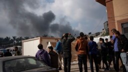 Warga Palestina melihat ke arah kepulan asap pasca serangan udara Israel di kota Khan Younis, Jalur Gaza selatan. 