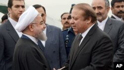 PM Pakistan Nawaz Sharif (kanan) menyambut kedatangan tamunya, Presiden Iran Hassan Rouhani di Islamabad hari Jumat (25/3).