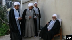 FILE - Grand Ayatollah Hossein Ali Montazeri sits during a gathering for Eid al-Fitr prayers in Qom, Oct. 1, 2008. Clerics from left are Mojtaba Lotfi, Abas Ali Fateh, and Montazeri's son Ahmad.