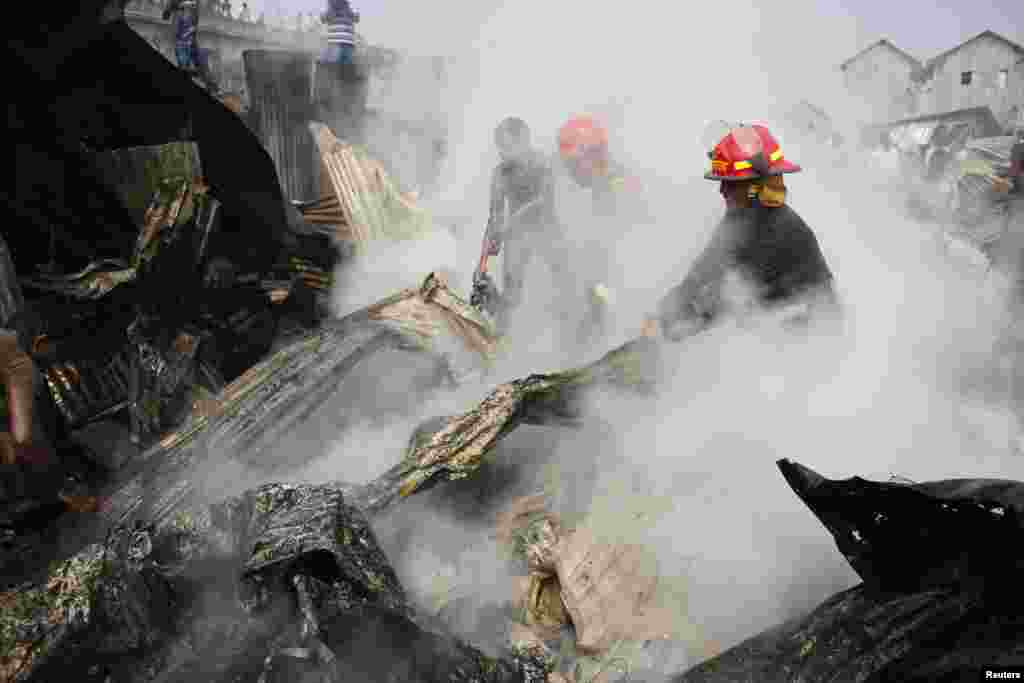 Firefighters attempt to put out a fire in a slum at Modhubagh in Dhaka, Bangladesh. A child was burnt alive and hundreds of shanties were gutted during the fire that originated from a cooking oven in the slum, firefighters said.