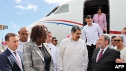 El presidente Nicolás Maduro conversa con el primer ministro de San Vicente y Las Granadinas, Ralph Everald Gonsalves al llegar a esa nación, el 14 de diciembre de 2023. A sus espaldas, se observa el avión incautado por Estados Unidos.