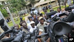 Nigeria's president Goodluck Jonathan (center right) fields questions from journalists as he leaves U.N. headquarters, where a day earlier a suicide bomber crashed through an exit gate and detonated a car full of explosives, in Abuja, Nigeria, August 2011