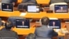 South Korean lawmakers watch screens showing a news broadcast of President Yoon Suk Yeol's speech on lifting martial law, at the main conference hall of the National Assembly in Seoul, early on Dec. 4, 2024.