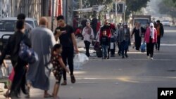 Warga Palestina yang membawa barang-barang seadanya, berusaha mengungsi ke wilayah yang lebih aman di Kota Gaza setelah serangan udara Israel yang masih terus berlanjut hari Jumat 13 Oktober 2023.