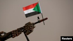 FILE —A Sudanese national flag is attached to a machine gun by Rapid Support Forces (RSF) soldiers as they wait for the arrival of Lieutenant General Mohamed Hamdan Dagalo.