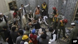 Pakistani security officials and rescue workers examine the site of bomb blast inside a mosque in Peshawar, Pakistan, March 09, 2013.