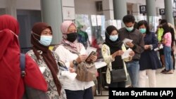 Para calon penumpang antre untuk tes virus corona untuk perjalanan kereta jarak jauh di Stasiun Pasar Senen, Jakarta, 9 Februari 2021. (Foto: Tatan Syuflana/AP)