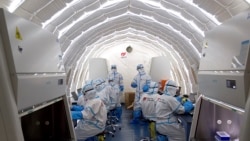 Sejumlah pekerja sedang bekerja di laboratorium pengujian COVID-19 di Beijing, China, 23 Juni 2020. (Foto: Chen Zhonghao/Xinhua via AP)