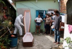 A funeral worker wearing protection gear prepares a coffin to remove the body of Raimundo Costa do Nascimento, 86, who died at home amid the new coronavirus pandemic in Sao Jorge, Manaus, Brazil, April 30, 2020.