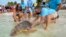 In this photo provided by the Florida Keys News Bureau, Bette Zirkelbach, front left, and Richie Moretti, front right, manager and founder respectively of the Florida Keys-based Turtle Hospital, release "Sparb," a sub-adult loggerhead sea turtle, Thursday