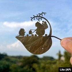 This undated photo provided by Japanese leaf-cutting artist Lito shows his work titled "Wait a second! That's my baby!"