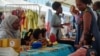 The Senegalese toymaker Awa Gaye presents her dolls to a girl at her stand, in Dakar, Senegal December 14, 2024.