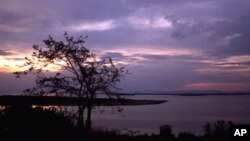 FILE - The sun sets over Lake George near Uganda's Queen Elizabeth National Park in western Uganda.