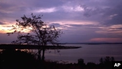 FILE - The sun sets over Lake George near Uganda's Queen Elizabeth National Park in western Uganda.