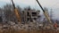 Workers remove debris of a destroyed building purported to be a vocational college used as temporary accommodation for Russian soldiers in Makiivka (Makeyevka), Russian-controlled Ukraine, Jan. 4, 2023. 