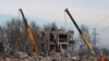 Trabajadores retiran los escombros de un edificio destruido que supuestamente era una escuela de formación profesional utilizada como alojamiento temporal para los soldados rusos, decenas de los cuales murieron en un ataque con misiles ucranianos el 1 de enero de 2023. 