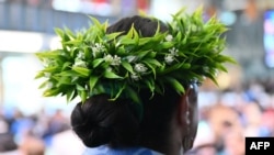 ARCHIVO - Una delegada luce una corona de flores al participar en la conferencia sobre biodiversidad de la COP16, en Roma, el 25 de febrero de 2025.