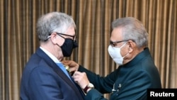 Microsoft co-founder turned philanthropist Bill Gates receives Hilal-e-Pakistan, the second-highest civil award, from Pakistani President Arif Alvi, in Islamabad, Feb. 17, 2022.