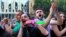 FILE - People react while listening to a speaker during a protest as opposition demonstrators gather in front of the Georgian parliament building, in Tbilisi, Georgia, June 24, 2019.