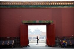 A visitor wearing a face mask to protect against the new coronavirus walks through the Forbidden City in Beijing, May 1, 2020.