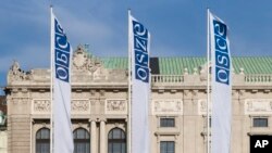 Bendera di depan pintu masuk kantor Dewan Tetap Organisasi untuk Keamanan dan Kerjasama di Eropa (OSCE) di Wina, Austria, 15 Februari 2022. (AP/Lisa Leutner)