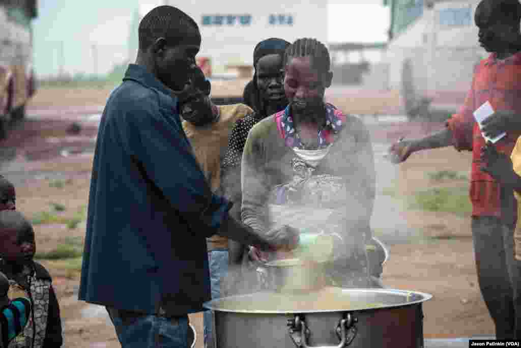 A South Sudanese refugee receives a warm meal at a reception center in Uganda.