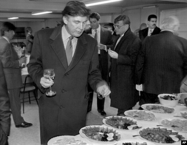 FILE - In this Nov. 5, 1996, photo, Donald Trump, then a real estate mogul and now the U.S. president, visits a reception as he checks out sites in Moscow, Russia, for luxury residential towers.