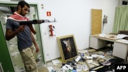 Ливийский повстанец в разгромленном офисе одного из приближенных Каддафи