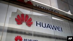 Logo Huawei di jendela toko ritel di Beijing, China, 29 Januari 2019. (AP Photo/Andy Wong)