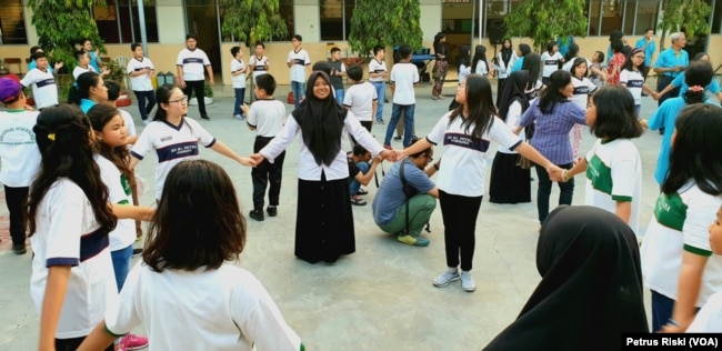 Siswa-siswi dari Madrasah Ibtidaiyah (MI) Islamiyyah-Plosogenuk, SD Kristen Petra, SD Katolik Wijana, dan sejumlah anak SD anggota jemaat GKJW Bongsorejo, bermain bersama sambil menanti waktu berbuka puasa (Foto: VOA/Petrus Riski).