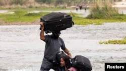 Migrantes venezolanos que buscan asilo cruzan el río Bravo hacia Estados Unidos desde México, en Del Rio, Texas, el 10 de mayo de 2021.