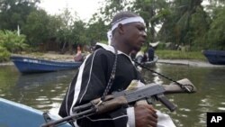 Wani sojan yan tawaye ne ke daga bindigarsa samfurin AK 47 a yayinda yake sintiri a yankin Niger Delta.