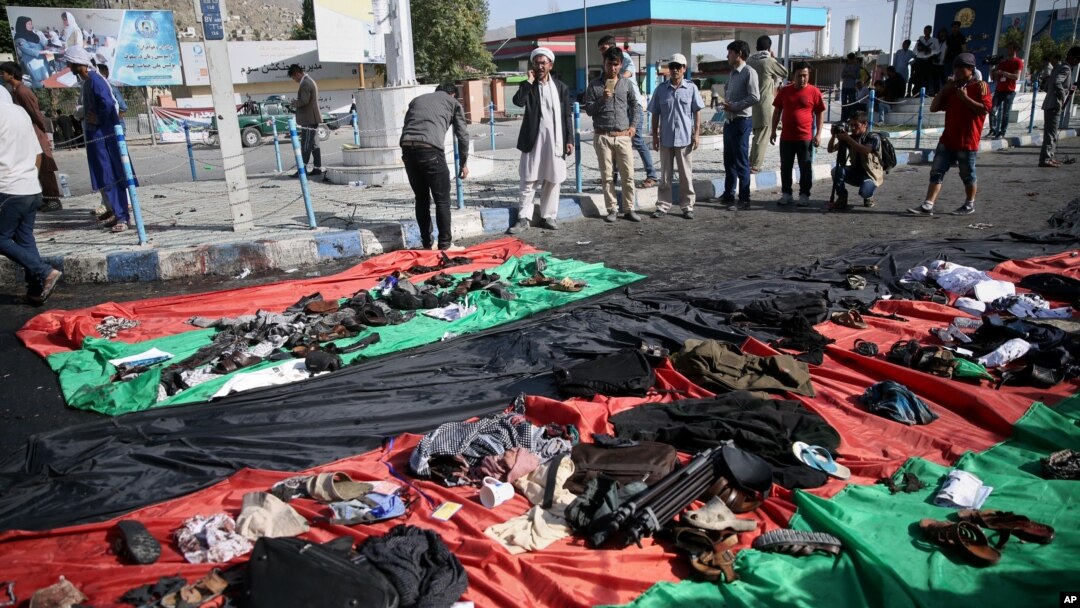Afg'on bayroqlarida - portlash qurbonlari buyumlari. Kobul, 23-iyul 2016-yil
