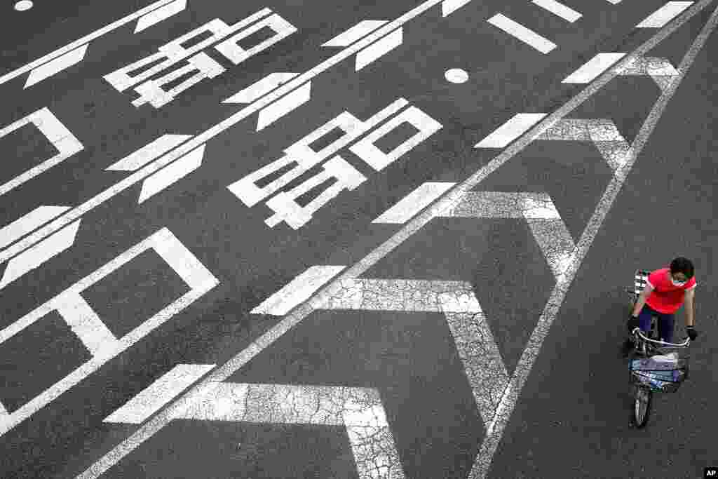 A man wearing a protective mask to help curb the spread of the coronavirus disease rides a bicycle at an intersection in Tokyo. 