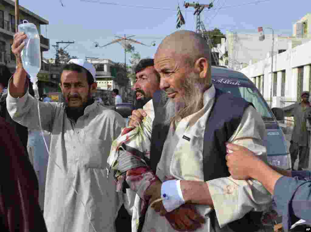 People rush an injured man to a hospital in Quetta, Pakistan, August 9, 2013.