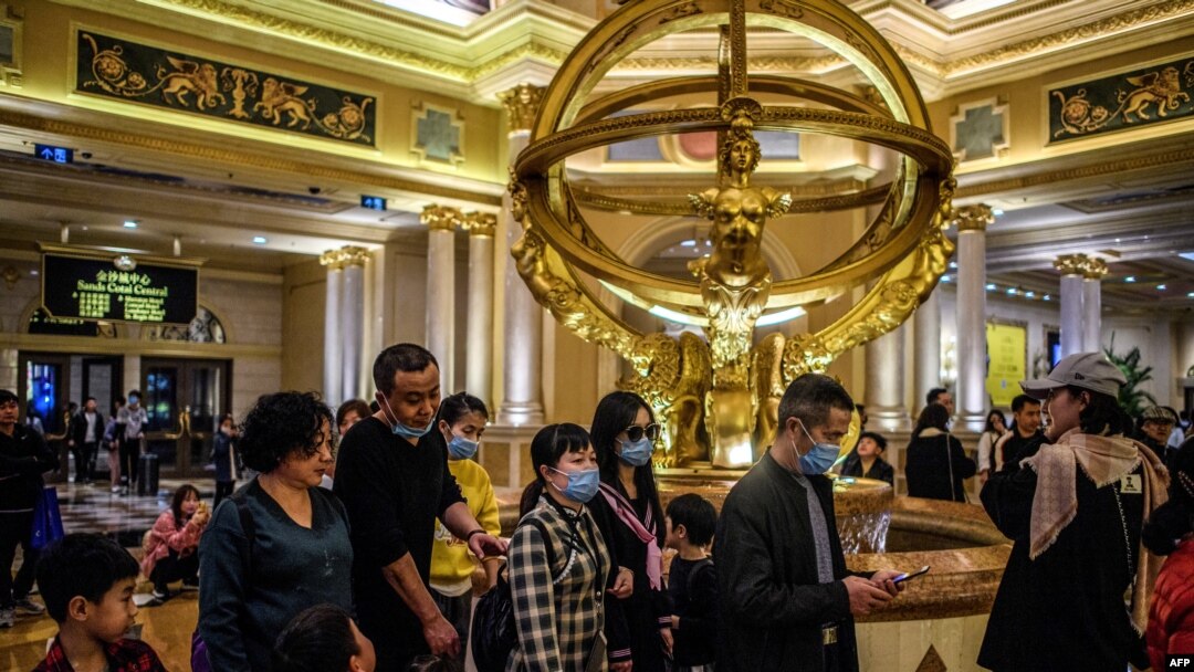 Para pengunjung sebuah resor hotel kasino di Makau mengenakan masker penutup mulut, 22 Januari 2020. (Foto: AFP)