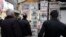 Iranians look at newspapers hanging on a news stand in central Tehran,, Feb. 25, 2012.