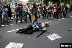 FILE - A man is down during a clash between members of white nationalist protesters and a group of counterprotesters in Charlottesville, Va., Aug. 12, 2017.