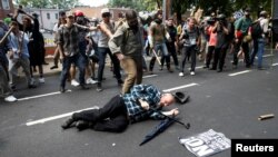 A man is down during a clash between members of white nationalist protesters and a group of counterprotesters in Charlottesville, Va., Aug. 12, 2017.