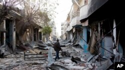 FILE - A Kurdish fighter walks through rubble in Kobani, Syria.