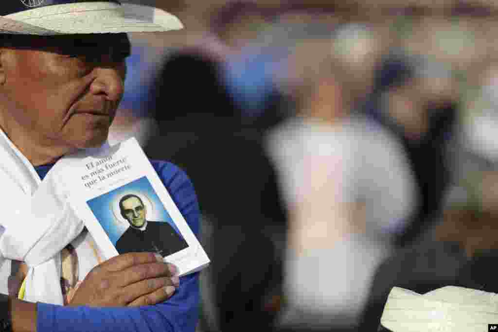 Un hombre sostiene una imagen del asesinado arzobispo salvadoreño Oscar Romero antes de su ceremonia de canonización en la Plaza de San Pedro en el Vaticano, domingo 14 de octubre de 2018. (Foto AP / Andrew Medichini)
