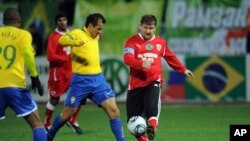 Chechnya leader Ramzan Kadyrov (r) fights for the ball with Brazil's 2002 World Cup-winning side player Dunga (c) during an exhibition match between Brazil's 2002 World Cup-winning side and 'team Kadyrov' in Grozny on March 8, 2011