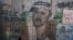 Woman passes near section of Israel's separation barrier depicting Yasser Arafat near the West Bank city of Ramallah, Aug. 8, 2012.