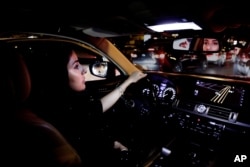 FILE - A Saudi woman drives her car down busy Tahlia Street in Riyadh, Saudi Arabia, June 24, 2018.