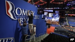 ພວກອາສາສະມັກ ກໍາລັງຕິດປ້າຍ ຊື່ທ່ານ Romney-Ryan ໃນກອງປະຊຸມທີ່ເມືອງ Tampa, Florida, 