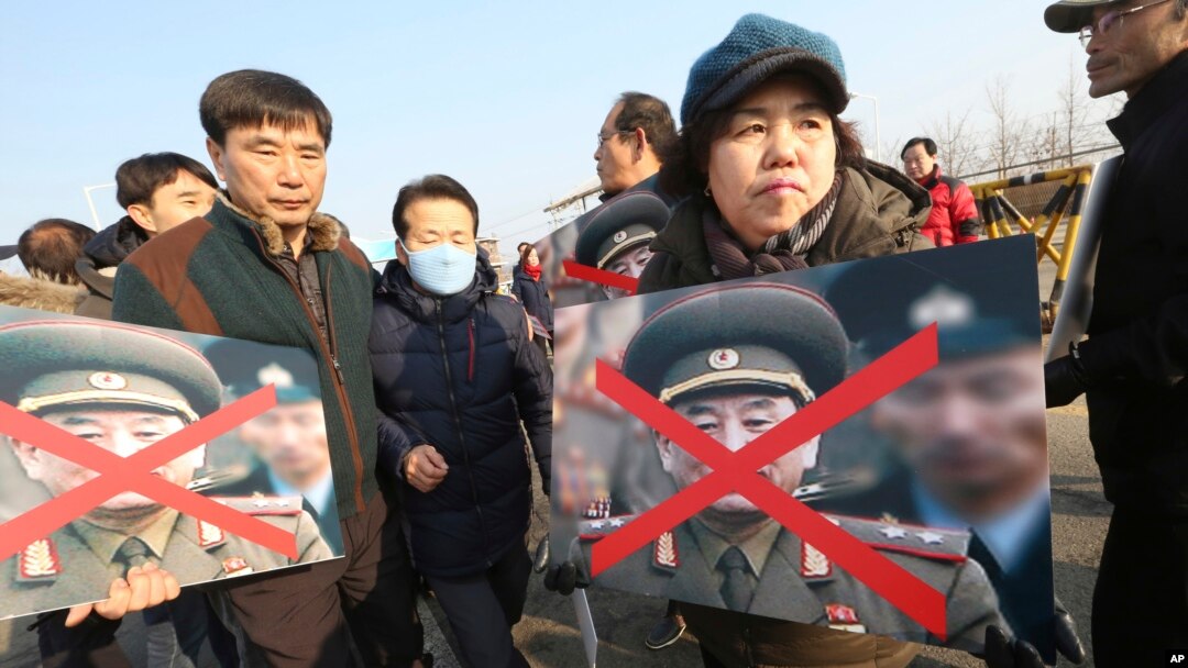 Članovi porodica žrtava sa južnokorejkog broda koji je potonuo nakon napada Severne Koreje drže precrtane portrete čelnika Severne Koreje tokom protesta u Pađu, Južna Koreja, 25. febraura 2018.