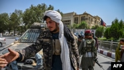 Taliban fighters stand guard along a street at the Massoud Square in Kabul on August 16, 2021.