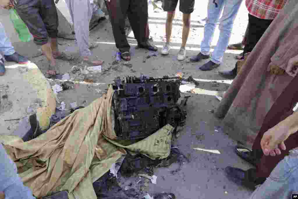Egyptians examine an engine believed to be from the car that was used in the bombing of the national security building in the Shubra el-Kheima neighborhood of Cairo, Aug. 20, 2015.